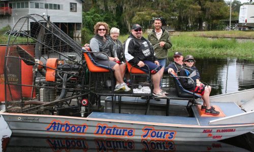 Group and airboat captain on boat before tour with Alligators Unlimited Airboat Tours