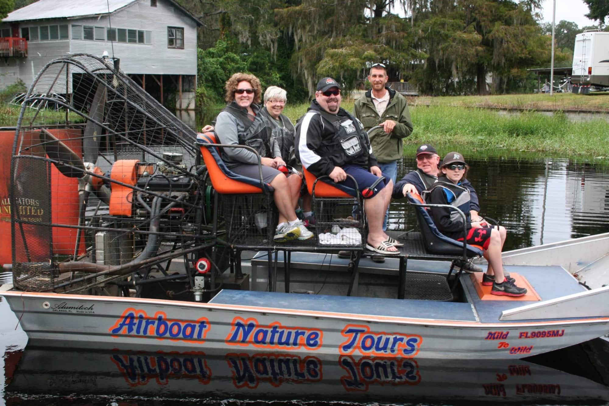 Group and airboat captain on boat before tour with Alligators Unlimited Airboat Tours