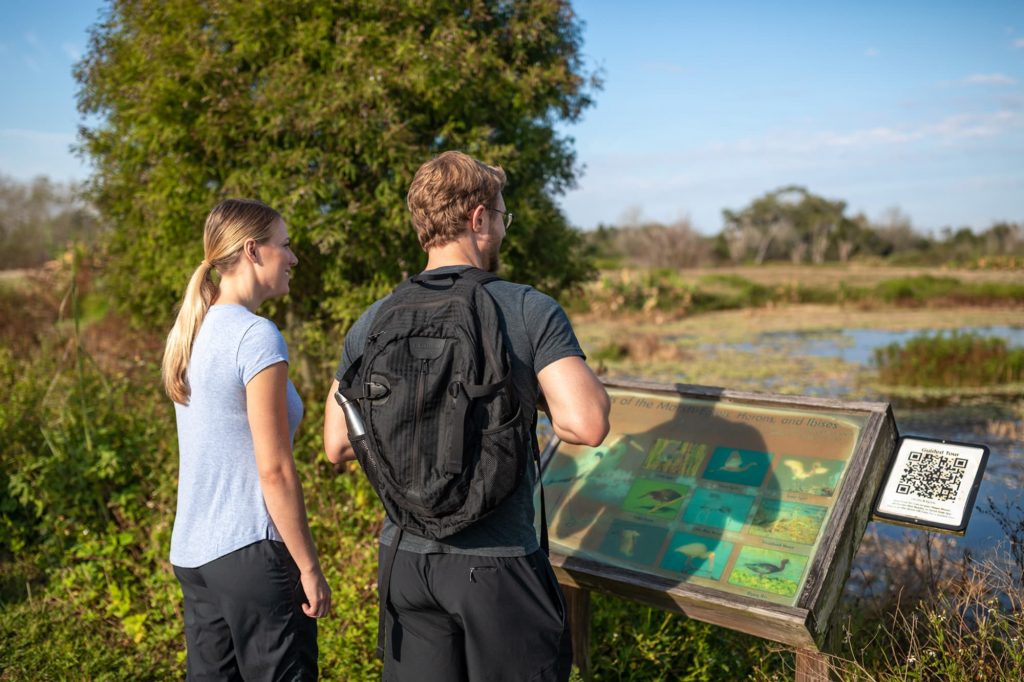 2 people reading trail sign overlooking lake at Circle B Bar Reserve in Lakeland, FL