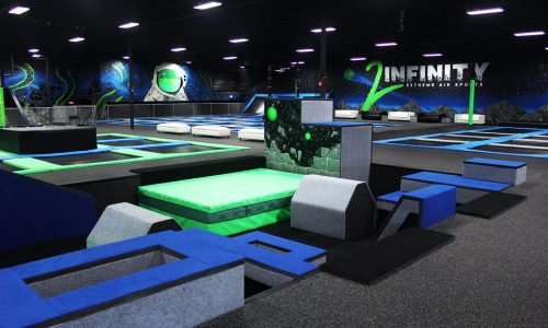 Open floor at DEFY Lakeland showing trampolines and agility boxes.