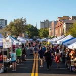 People and vendor tents along Kentucky Ave. in downtown Lakeland during Downtown Farmers Curb Market on Saturday morning.