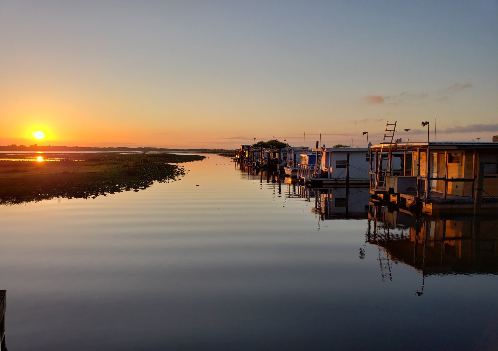 Sunrise over lake and rental cabins at Grape Hammock Fish Camp and Airboat Rides in Lake Wales, FL
