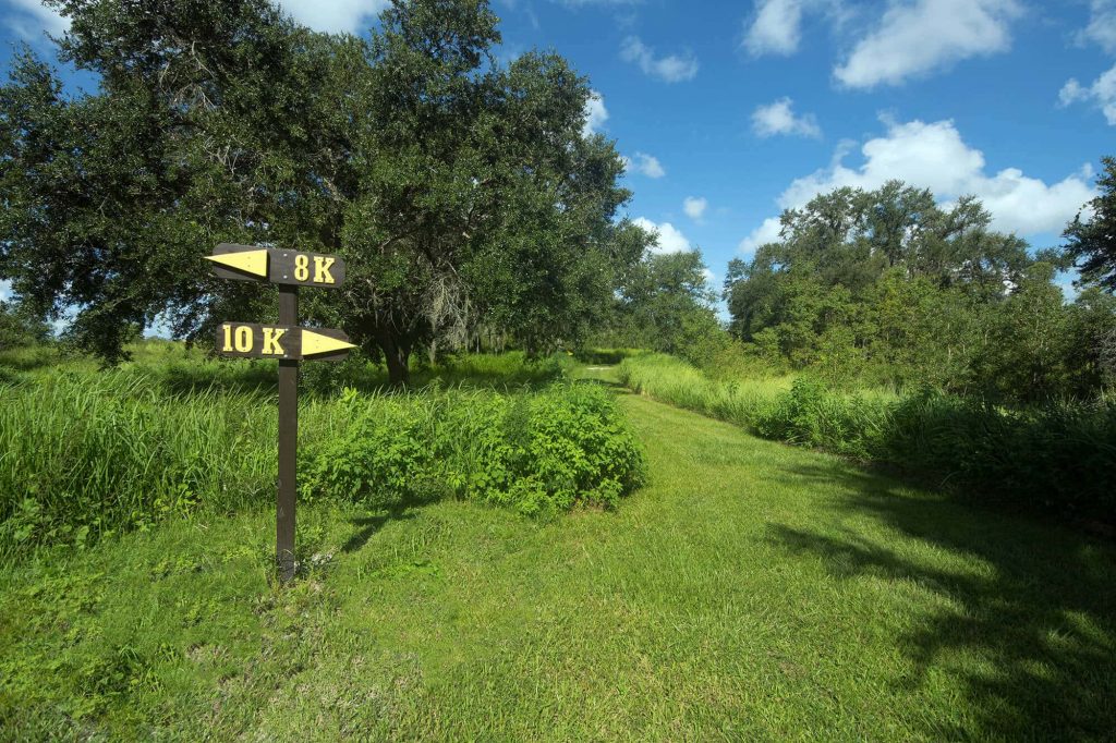 8K and 10K trail markers and grassy running path at Holloway Park in Lakeland, FL