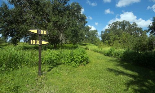 8K and 10K trail markers and grassy running path at Holloway Park in Lakeland, FL