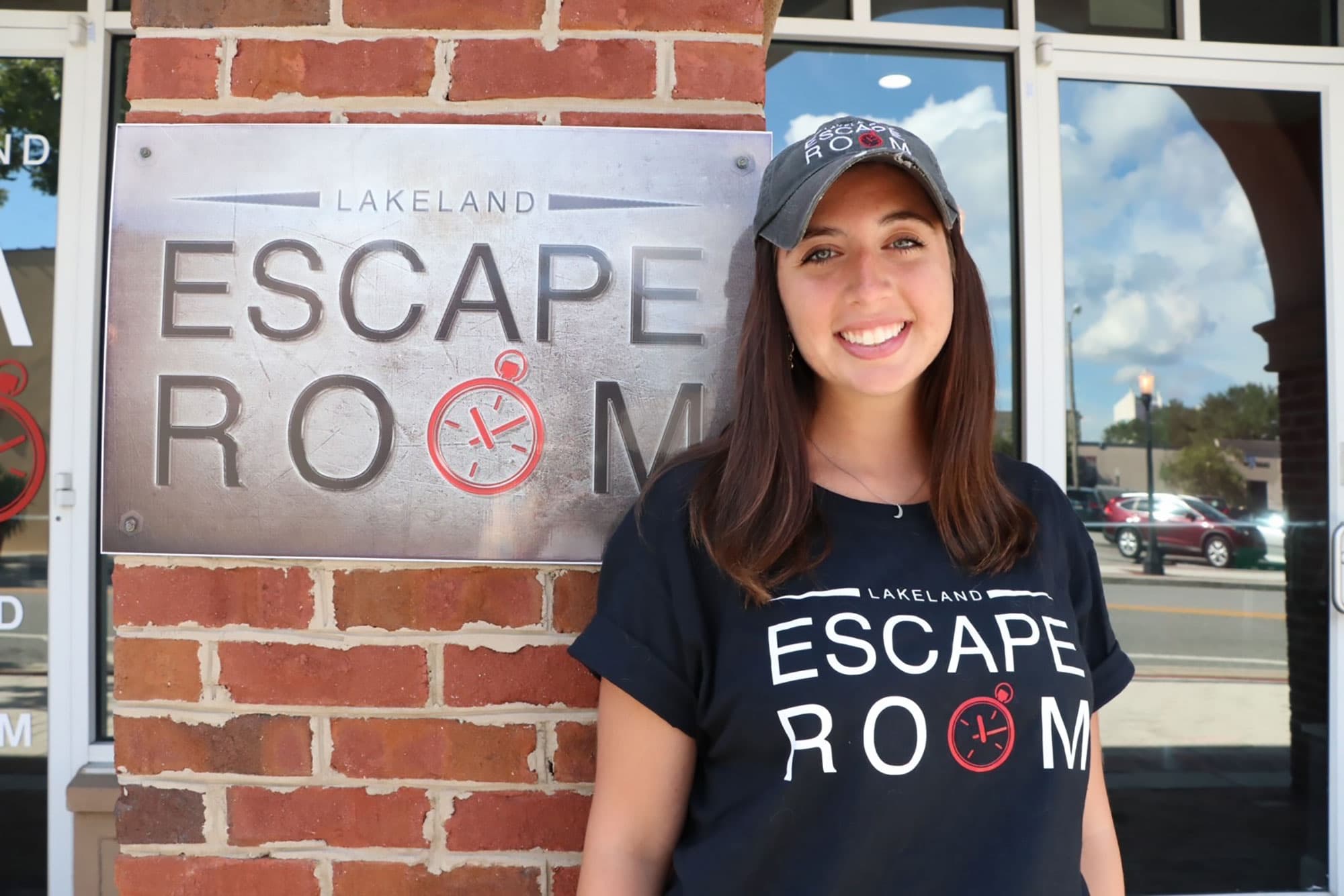 woman standing in front of Lakeland Escape Room sign