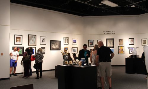 Visitors looking at art during Student Art Exhibition at Polk State College Lakeland Art Gallery.