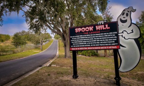 Road and sign explaining history of Spook Hill in Lake Wales, FL