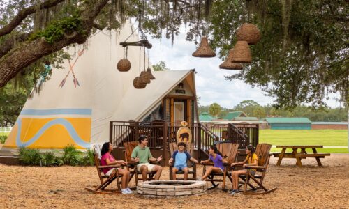 Family sitting outside luxe teepees at Westgate River Ranch Resort & Rodeo