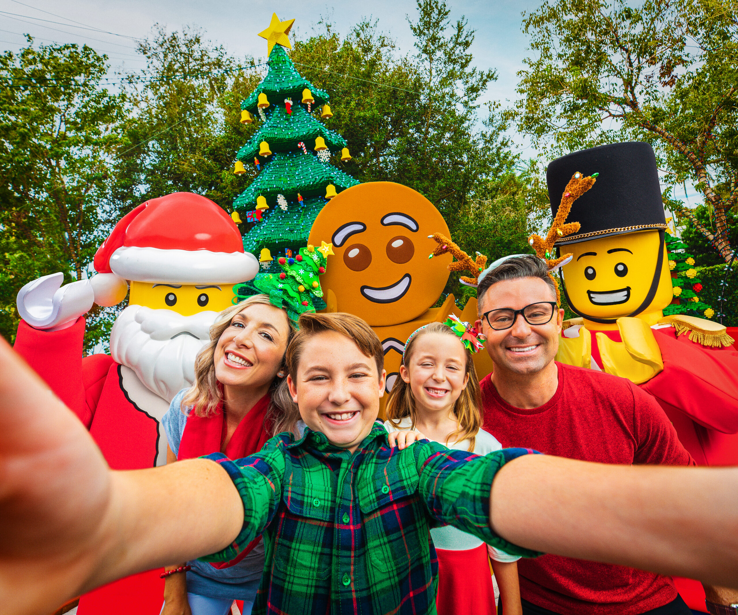 Family of four taking a selfie with LEGOLAND Florida Christmas characters