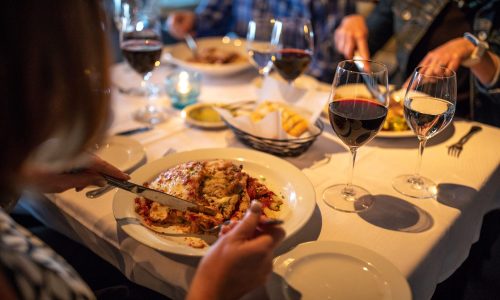 3 people eating Italian dishes, water and wine glasses at Scarpa's Italian in Lakeland, FL