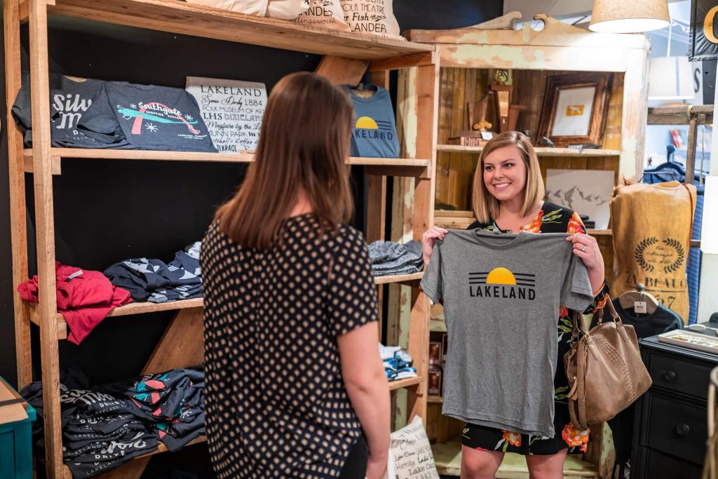 2 females shopping for Lakeland themed t-shirts inside Scout & Tag in Lakeland, FL