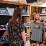 2 females shopping for Lakeland themed t-shirts inside Scout & Tag in Lakeland, FL