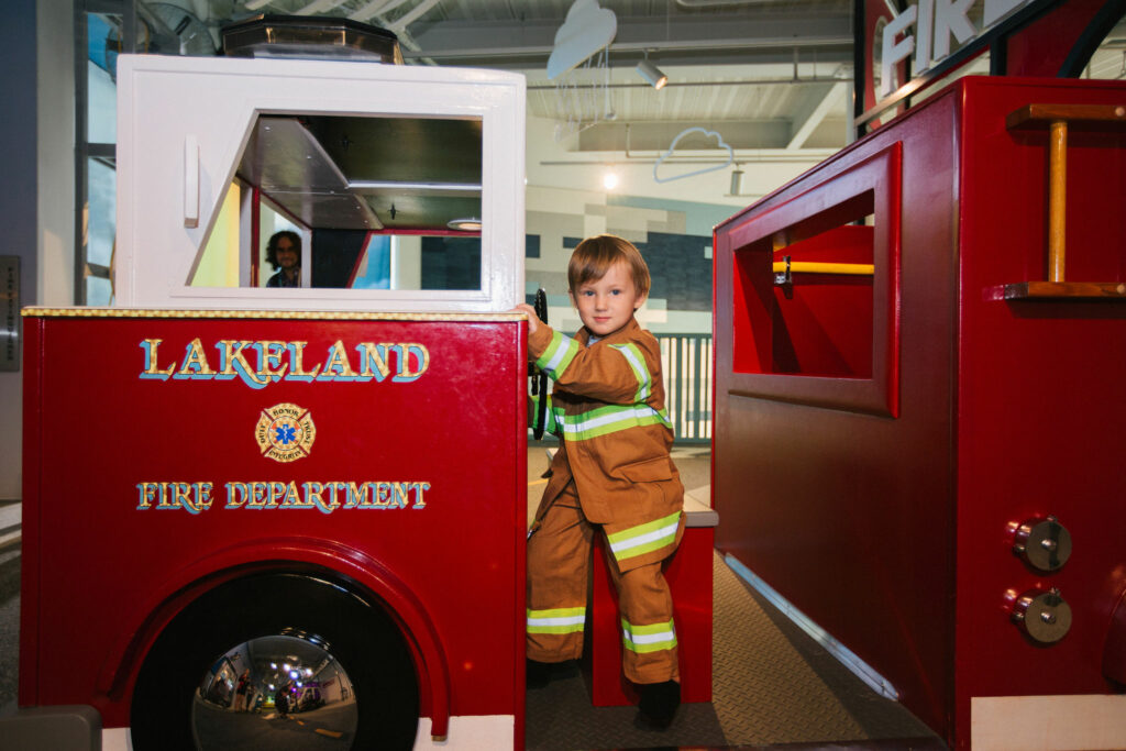Boy playing on firefighter truck at the Florida Children's Museum