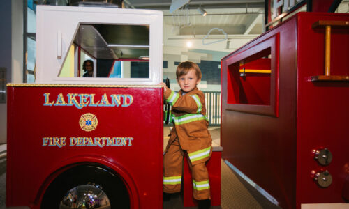 Boy playing on firefighter truck at the Florida Children's Museum