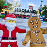 LEGO Santa and LEGO Gingerbread man standing outside LEGOLAND Florida Resort main entrance.