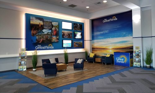 Visit Central Florida branded lounge with sitting area, brochure racks and video screens inside RP Funding Center in Lakeland, FL