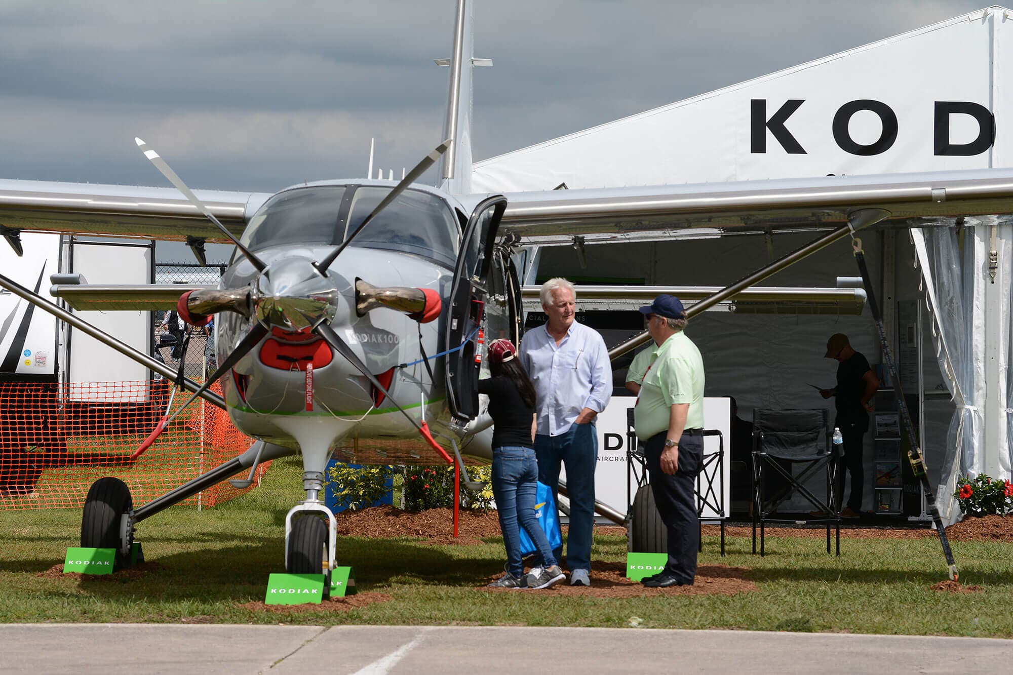 propeller airplane sale rep speaking with couple while looking at plane near vendor tent at SUN 'n FUN Aerospace Expo in Lakeland, FL