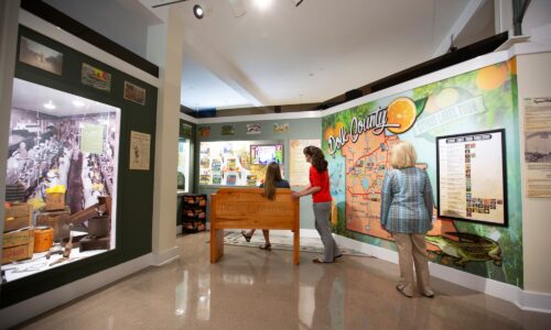 3 women looking at citrus themed Polk County exhibits inside Polk County History Center in Bartow, FL