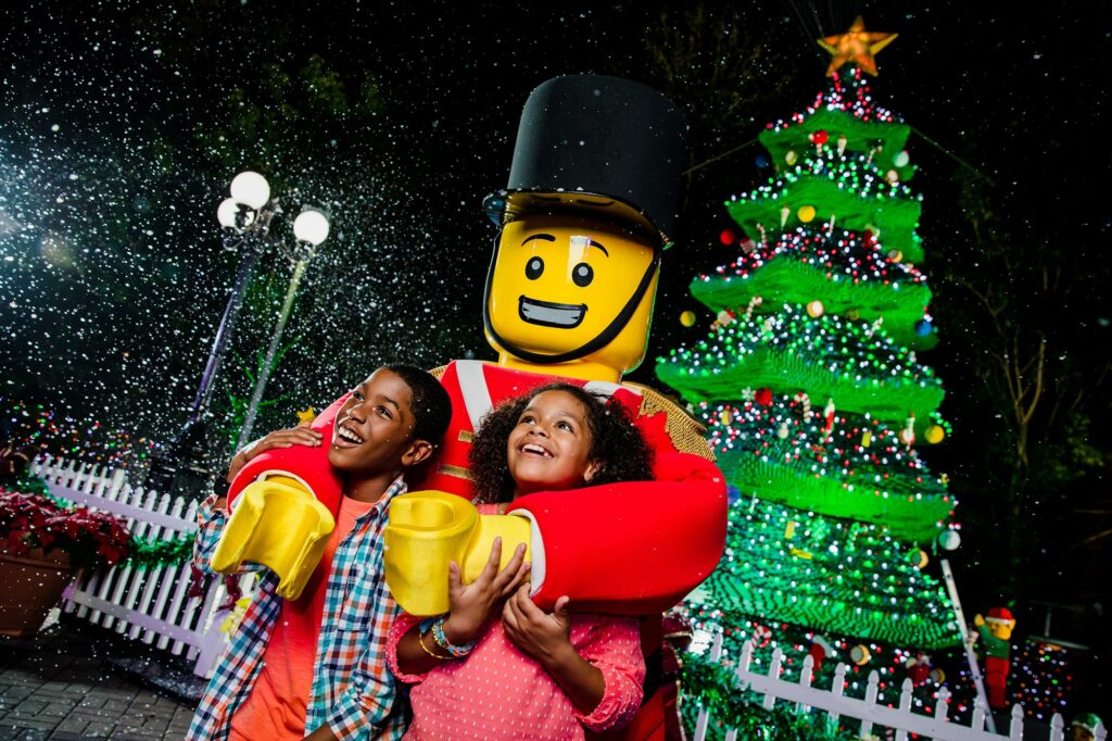 Santa y 2 niños con árbol de Navidad de fondo durante las vacaciones en LEGOLAND