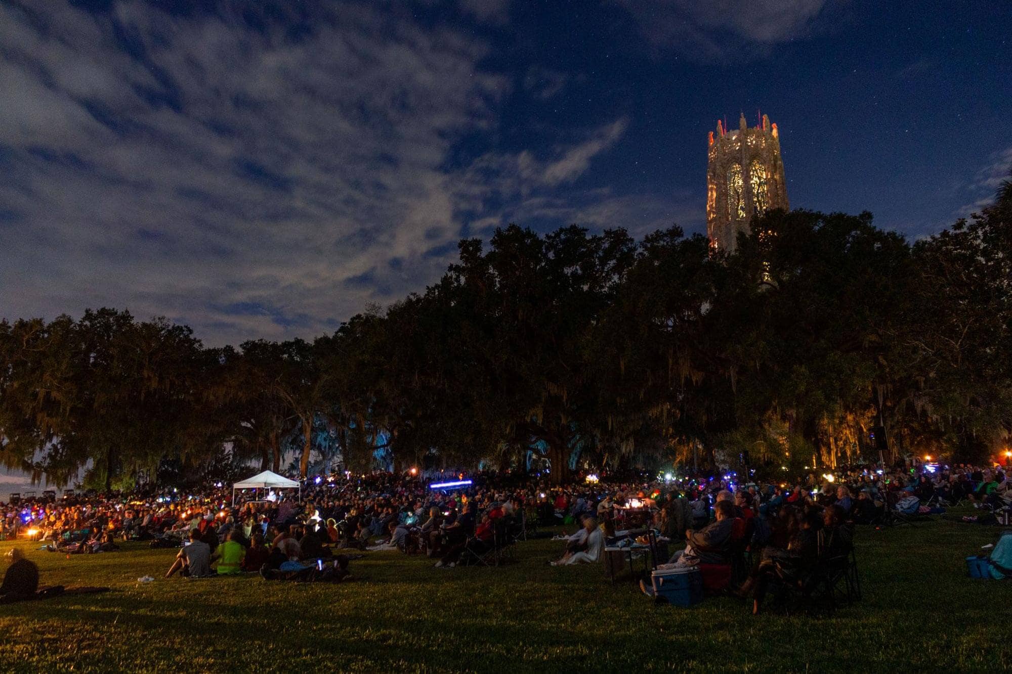 crowd gathered for moonlight concert at Bok Tower Gardens. Carillon tower in background.