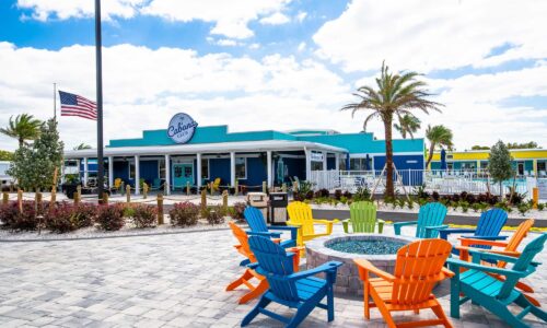 Patio and check-in building at Cabana Club Resort featuring cottages and RV slots.