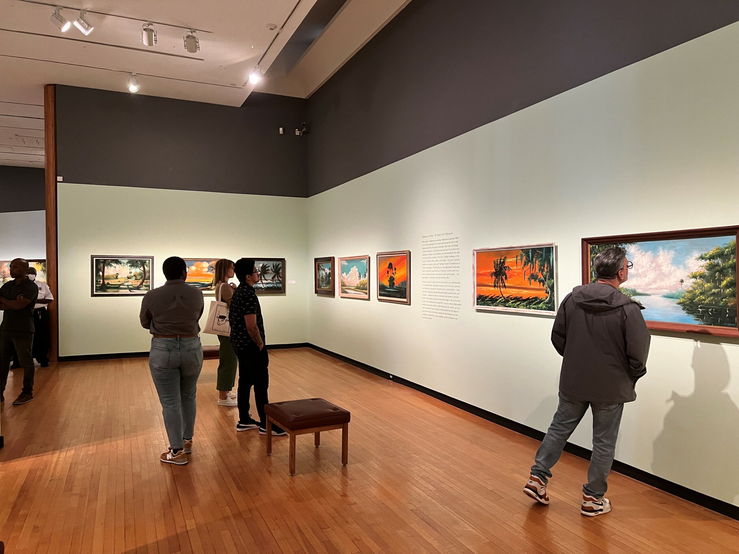 Guests in a gallery viewing works from the Highwaymen Exhibition