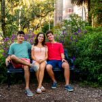 mother and her 2 sons sitting on a bench at bok tower gardens in lake wales, fl