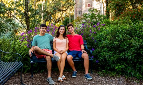 mother and her 2 sons sitting on a bench at bok tower gardens in lake wales, fl