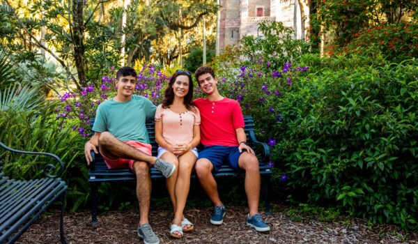 mother and her 2 sons sitting on a bench at bok tower gardens in lake wales, fl