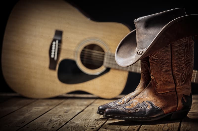Hearts and Cowboys festival image with guitar, cowboy hat and boots