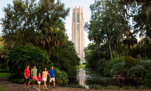 family of four walking in front of Bok Tower Gardens in Lake Wales, FL. One of the 50+ ways to experience Lakeland & Winter Haven