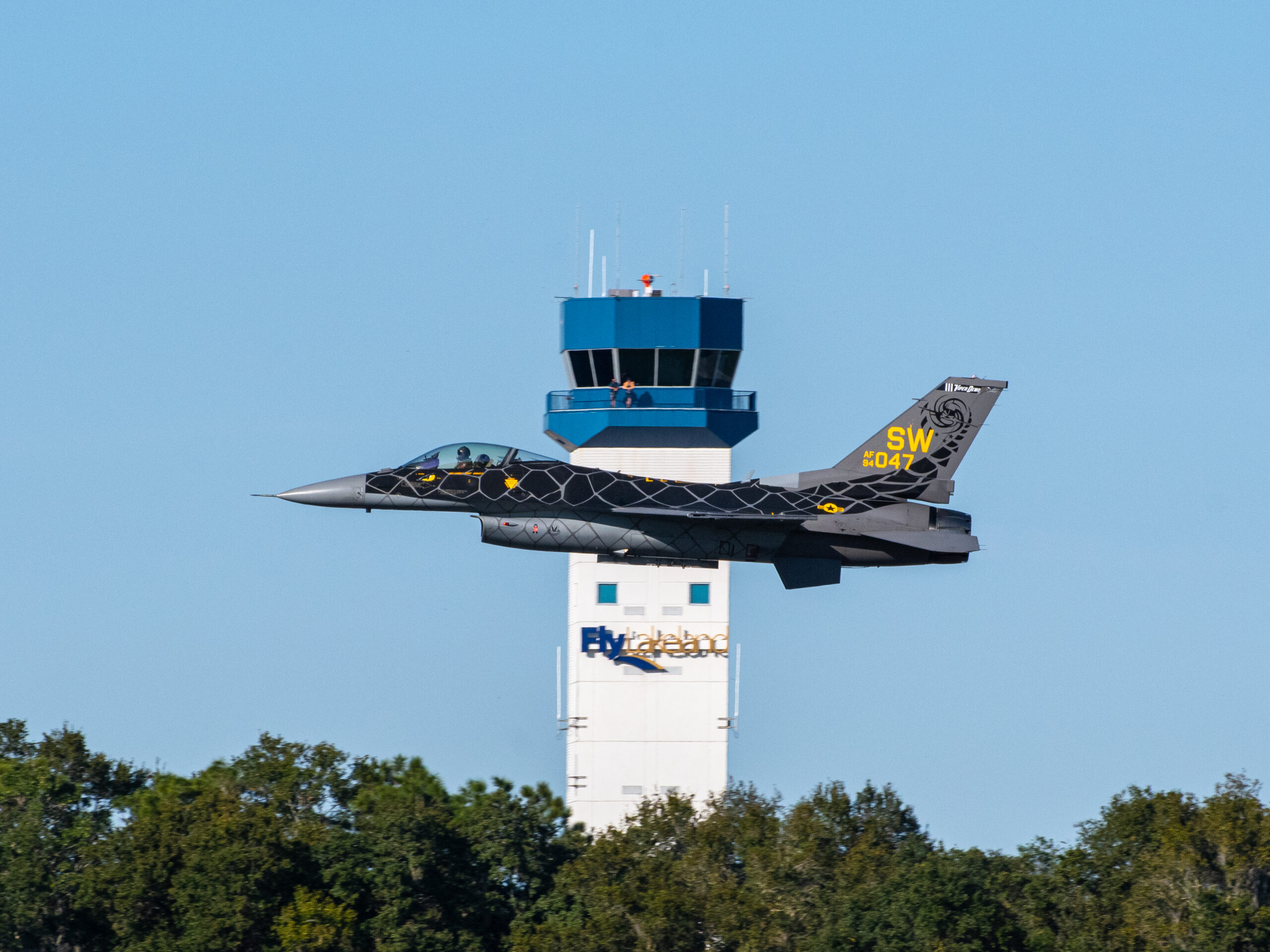 plane flying in front of Lakeland air traffic control tower