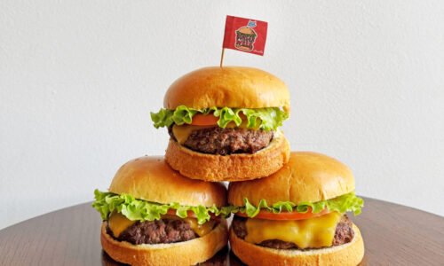 3 burgers stacked on each other with burger week flag